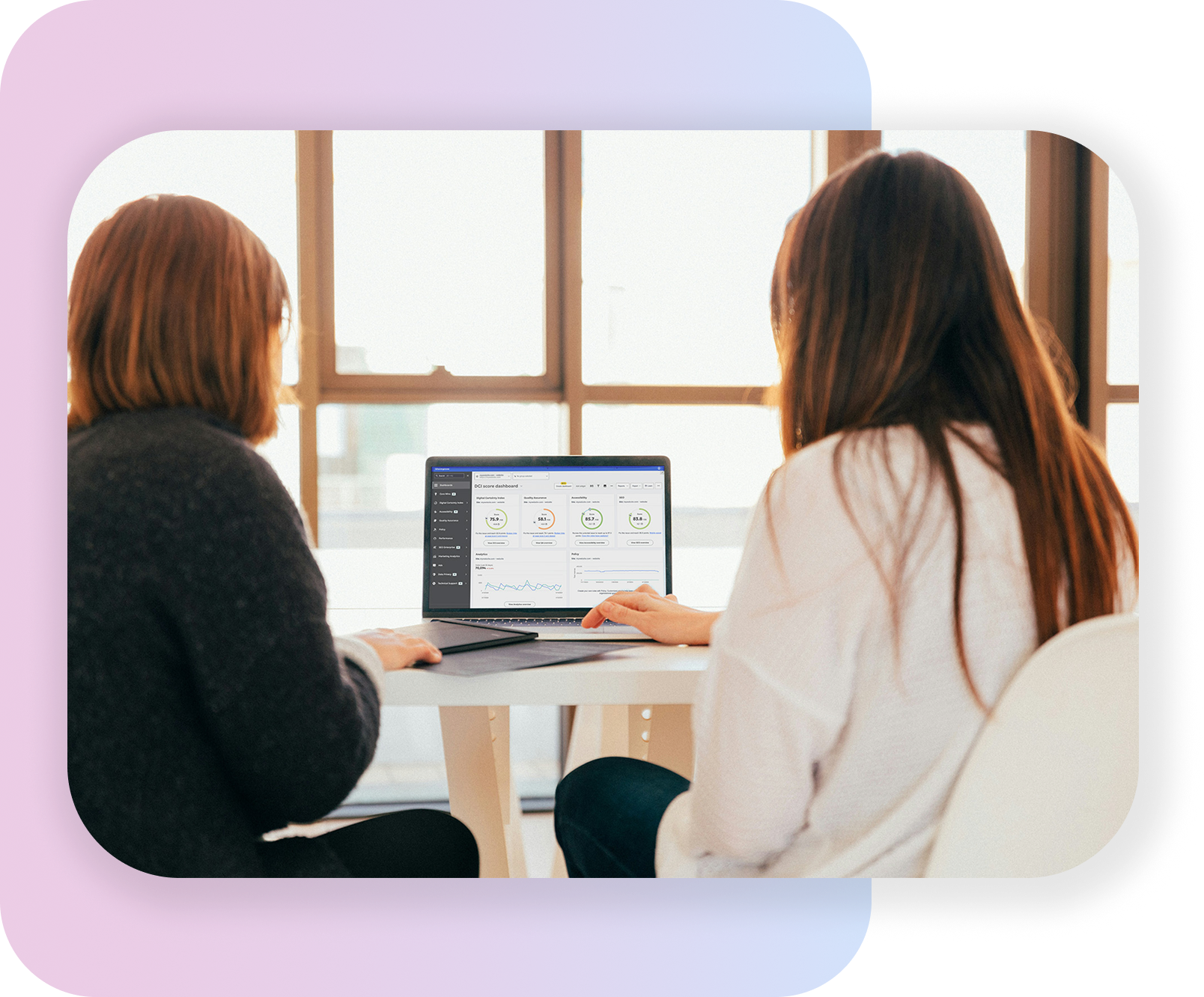 Two professionals collaborating while reviewing a dashboard on a laptop.