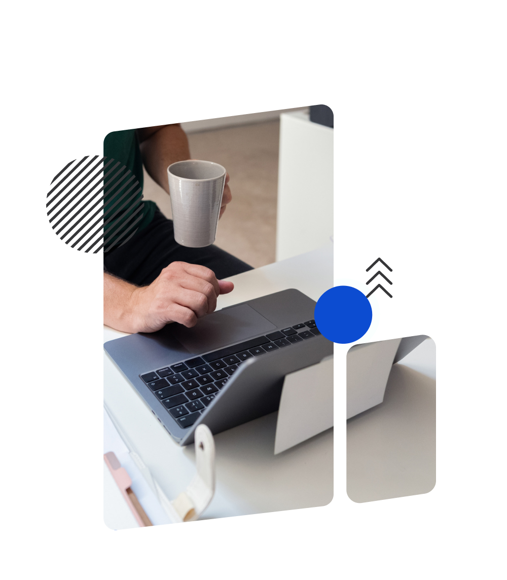 Person holding a mug while using a laptop, preparing for mobile accessibility testing.