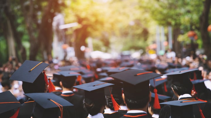 Group of students with graduation caps on at their graduation.