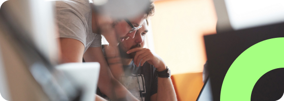 Two people looking at a computer testing their website accessibility.