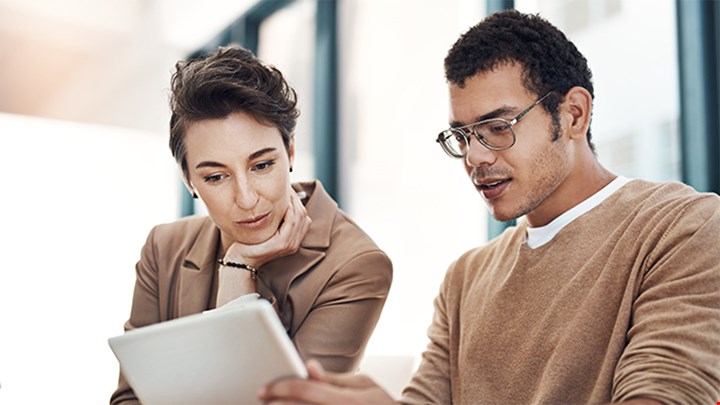 Two people Looking at a report during a meeting.